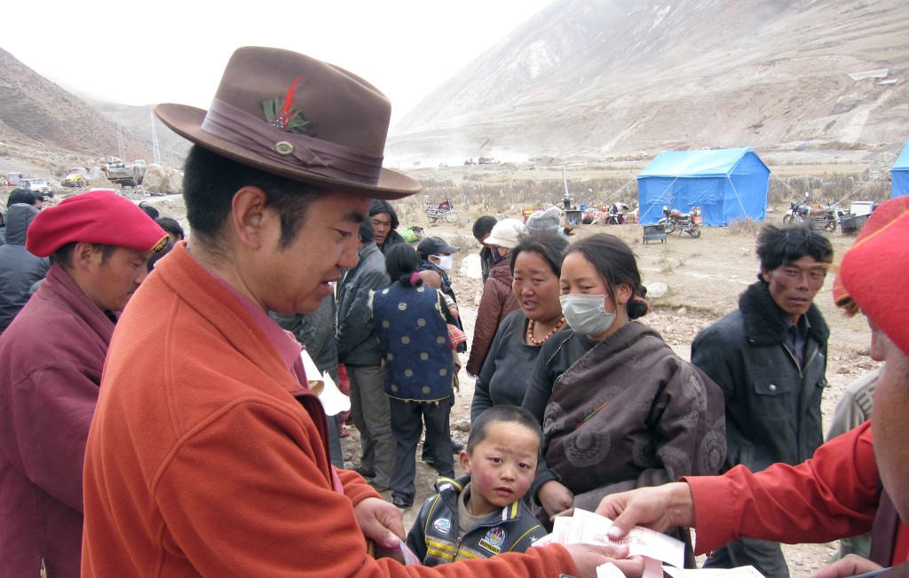 Surmang Khenpo distributing aid to families in need